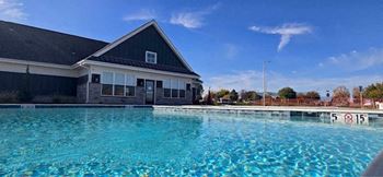 A swimming pool in front of a building with a no swimming sign.
